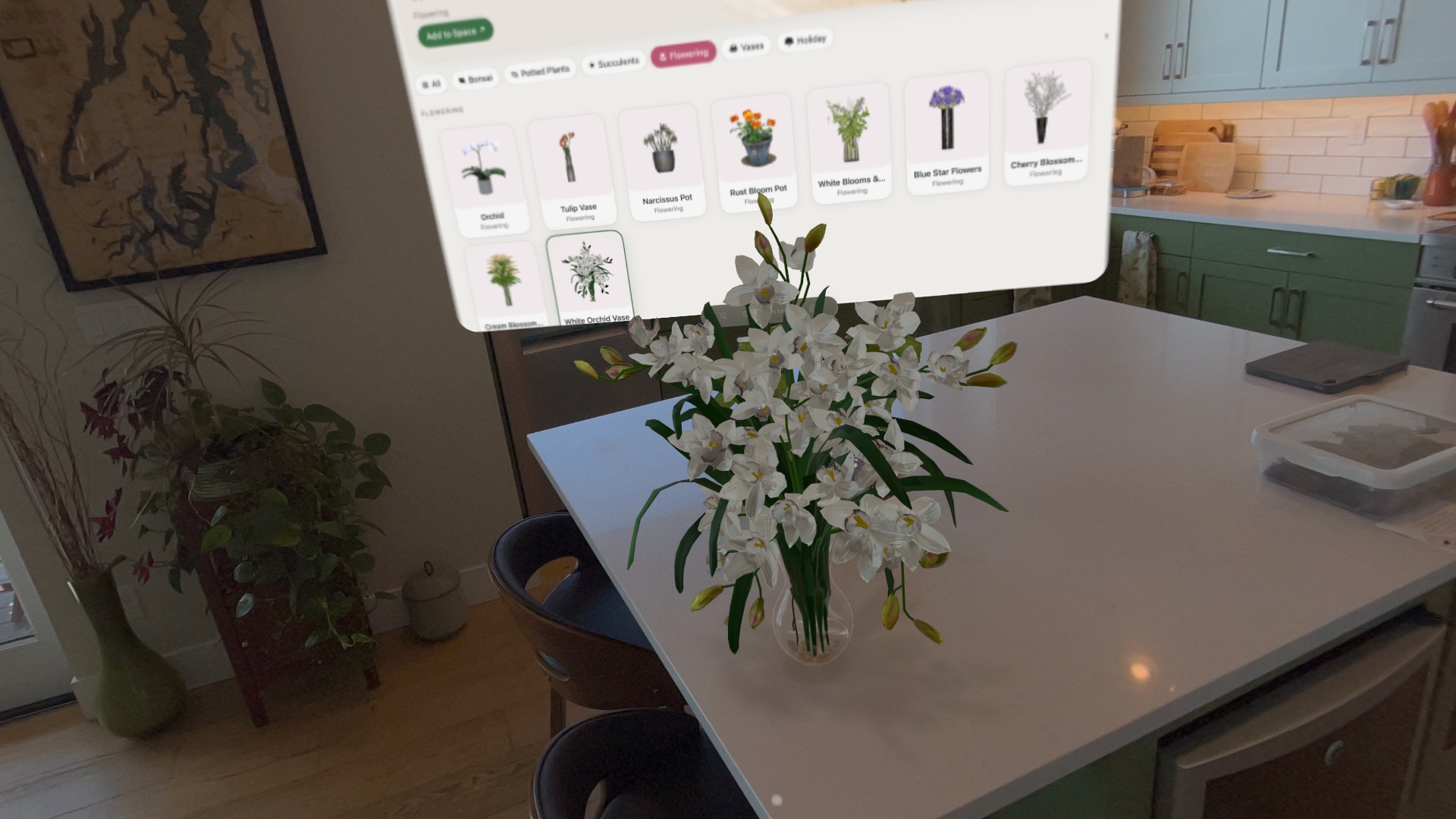 The Plantelier catalog floating above a kitchen island, with a vase of white orchids placed on the counter